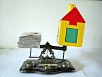 A scale with a House on One Side and Paperwork on the Other - Kathbern Management Toronto Recruiting Firm